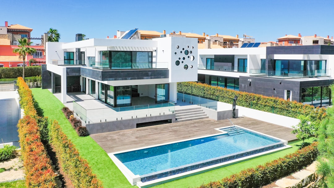 a large white house with a pool in front of it s7capthjcrq